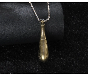 Détail d'un pendentif poisson en bronze avec chaîne argentée sur cuir noir