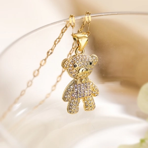 Macro shot of gold-plated bear pendant with white and purple cubic zirconia stones