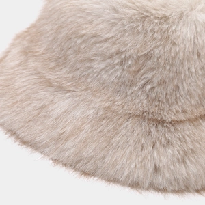 Gros plan sur la texture en fausse fourrure douce d'un chapeau bob d'hiver beige