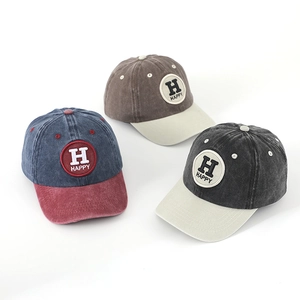 Detailed macro view showing three color variations of washed cotton Happy baseball caps