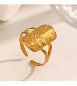 Detailed close-up of a gold rectangle star and moon ring with engraved celestial pattern