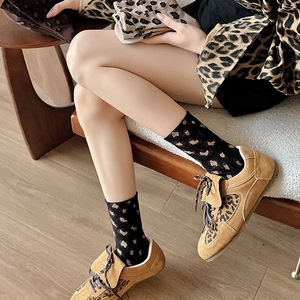 Knitted mid-calf leopard print socks styled with suede loafers for a trendy autumn look