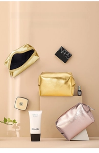 Detailed view of gold and rose gold waterproof cosmetic bags on a tiered display stand