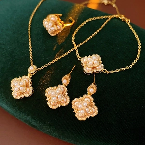 Détail d'un ensemble de bijoux à fleurs dorées avec perles et cristaux sur velours