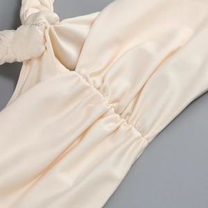 Detailed close-up of ribbed knit fabric featuring shoulder knot and pleated bust design