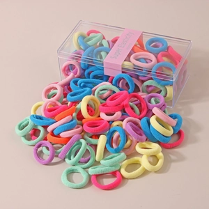 Macro shot of 80 mixed macaron elastic hair ties spilling from a clear storage box