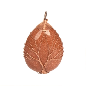 Macro shot of handmade copper tree of life wire wrapping on teardrop brown crystal