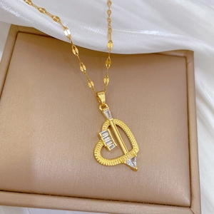 Dettaglio del ciondolo a cuore dorato con zirconi chiari su catena piatta elegante