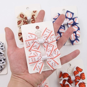 Detail of handmade sports-themed hair bows featuring baseball and football prints