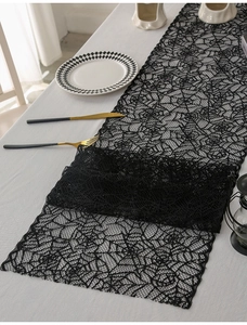 Close-up of black lace spider web table runner for Halloween festive fireplace decor
