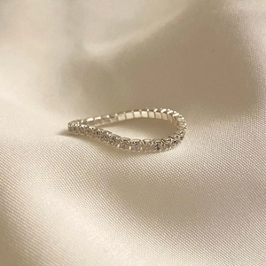 Macro close-up of S925 sterling silver ring with white zircon stones on textured fabric