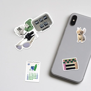 Detail of waterproof ins style stickers showing vintage clock and cute dog on a smartphone