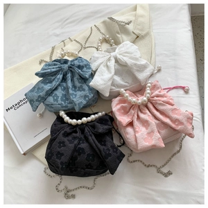 Detail of colorful bow bags with pearl handles in blue, white, black and pink colors