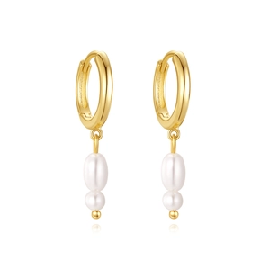 Detail of gold hoop earrings with elegant white pearl drops in a minimalist presentation