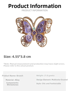 Detailed view of gold butterfly brooch with purple enamel wings and clear crystals