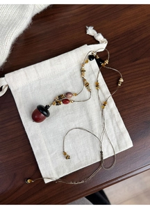 Macro shot of vintage hazelnut pendant necklace with ethnic beads on linen bag