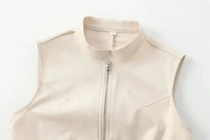 Detail von silbernem Metallreißverschluss und Stehkragen am beige gewebten ärmellosen Kleid