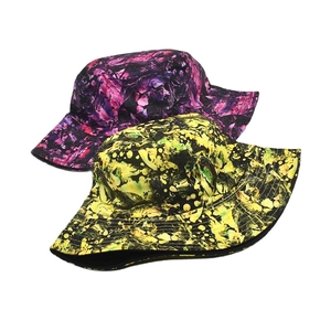 Close-up of double-sided tie-dye bucket hats in purple and lime ink-wash patterns