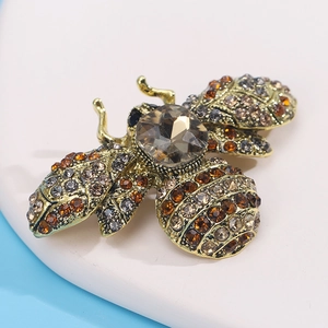 Macro shot of vintage bee brooch with brown crystals and rhinestones in gold finish