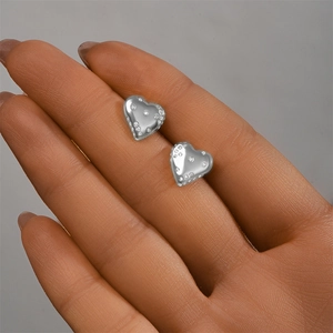 Detailed macro view of S925 sterling silver heart stud earrings with sparkling pavé zircons