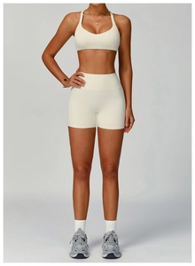 Detail of high-waisted recycled sports shorts and sports bra in off-white fabric
