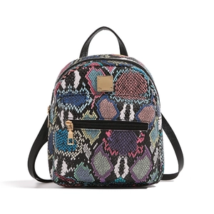 Detailed view of fashionable backpack featuring colorful snakeskin pattern and gold hardware