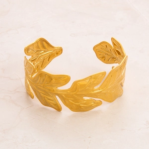 Macro detail of 18k gold plated stainless steel bracelet with engraved leaf patterns