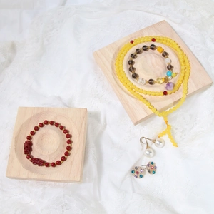 Detailed flat lay of diverse beaded bracelets and pearl earrings on wooden jewelry trays