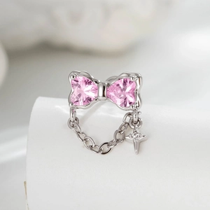 Silver bow earrings featuring pink heart stones and a delicate cross chain pendant