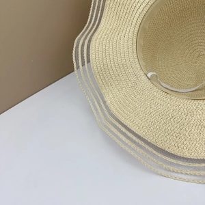 Detail of wide brim straw sun hat with lace mesh stripes and adjustable wind rope