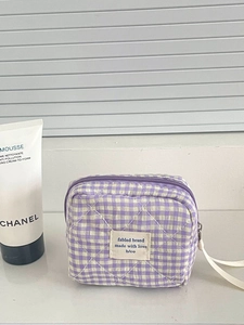 Primer plano de una bolsa de almacenamiento acolchada a cuadros morados con etiqueta