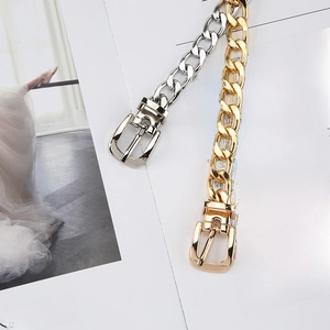Chic gold and silver curb chain belts with buckle closure on minimalist magazine background