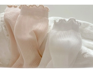 Macro view of breathable hollow knit pattern and ruffle cuffs on these kids socks