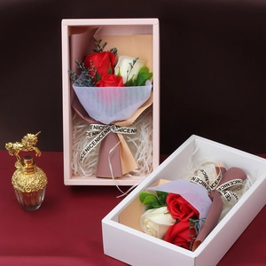 Detail of handmade soap rose gift boxes in pink and white with decorative mesh and ribbons