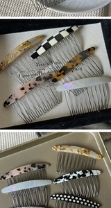 Close-up of acetate hair combs in checkered and tortoiseshell patterns on metal tray