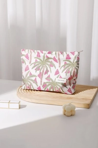 Macro detail of watermelon and palm tree embroidery on a canvas makeup bag with zipper