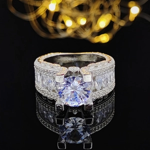 Detailed close-up of a luxury silver band ring featuring a large round-cut sparkling center stone