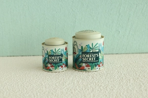 Macro view of cream tin canisters with forest style bunny illustrations for tea storage