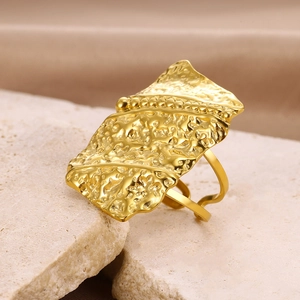 Macro shot of gold geometric ring with hammered texture on minimalist stone base