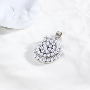 Macro d'un pendentif coquillage argenté serti de perles blanches avec anneau de suspension