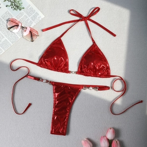 Detailed view of red metallic bikini with pearl accents and gold ring connectors