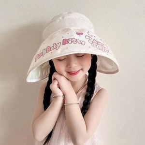 Detail of baby knitted hat with cream fabric and cute pink cat pattern print