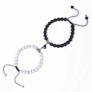 Detail of magnetic heart clasp connecting black stone and white turquoise bead bracelets