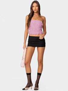 Rosa 3D-Blumen-Bandeau-Top und schwarzer Minirock, präsentiert von einem Modell