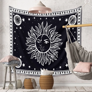 Detail of bohemian black and white sun and moon mandala tapestry on a textured wall