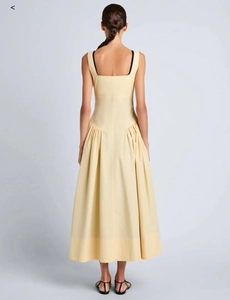 Détail du dos de la robe sans manches jaune pâle élégante avec jupe évasée plissée