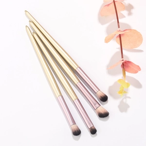 Detailed close-up of 4-piece eye makeup brush set with golden handles and soft bristles