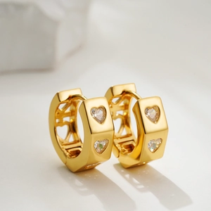 Vue macro de boucles d'oreilles cœur en or serties de zircons à la coupe cœur