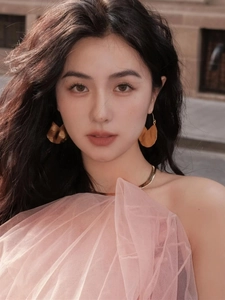 Detail of model wearing 18K gold plated irregular geometric earrings with a gold necklace
