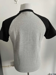 Dettaglio del retro di una t-shirt grigia in maglia waffle con maniche raglan nere